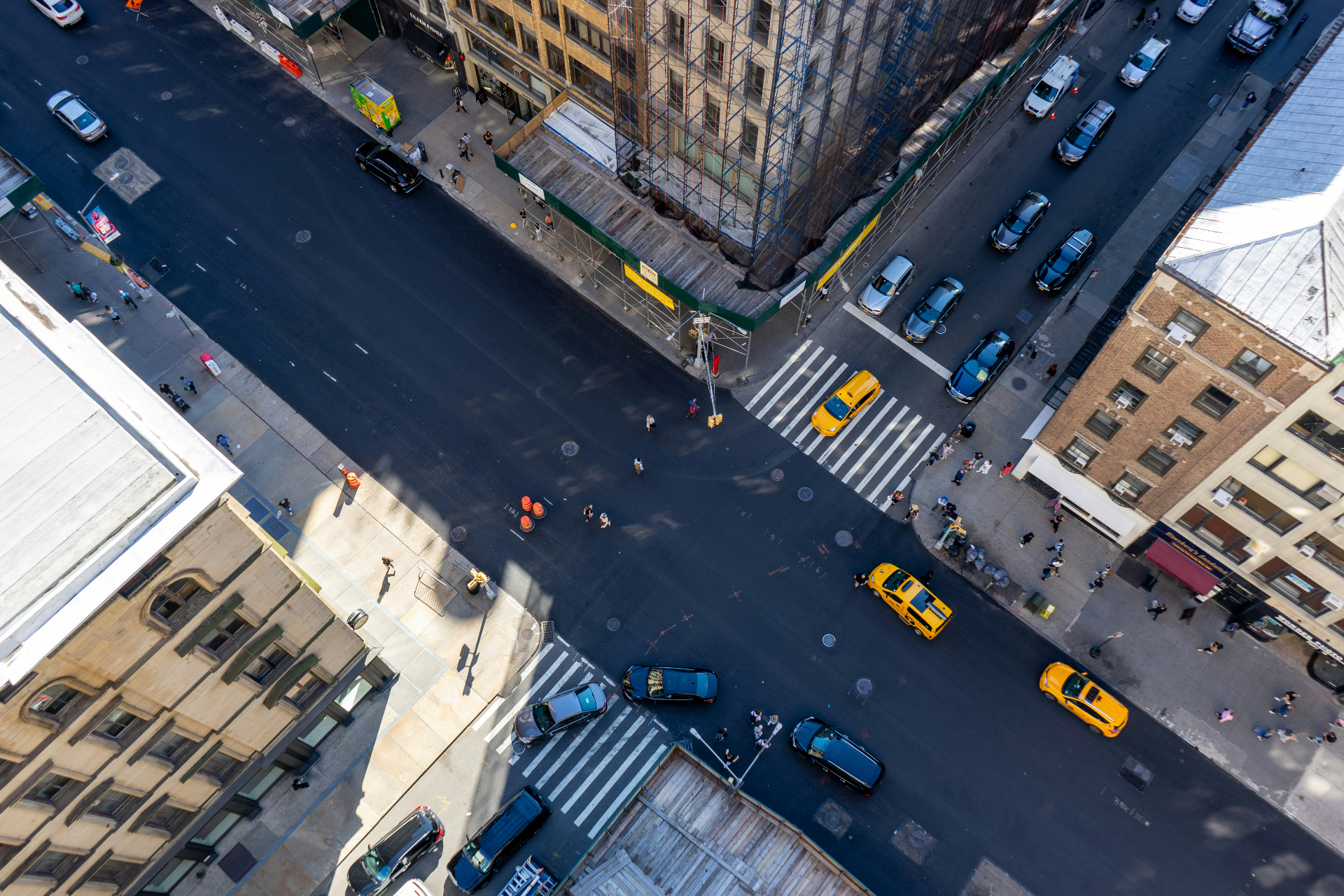 Aerial view of a city intersection with traffic and pedestrians